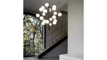 Lampada a sospensione Copernico in metallo verniciato nero opaco con dettagli in ottone e diffusori in vetro incamiciato bianco soffiato e acidato di Ideal Lux