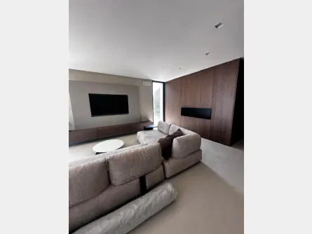 Living contemporaneo tra boiserie in legno e design minimale